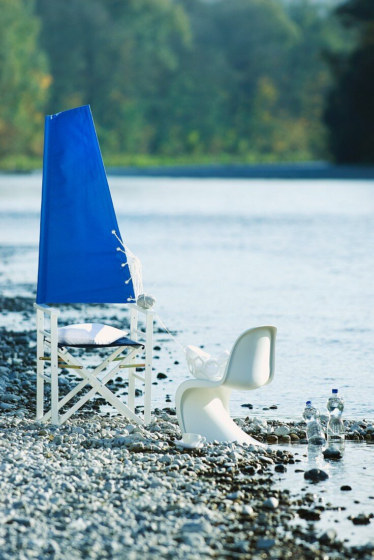 Originelle Stuhldeko (blaues Segel über der Stuhllehne) für eine Sommerparty am Flussufer