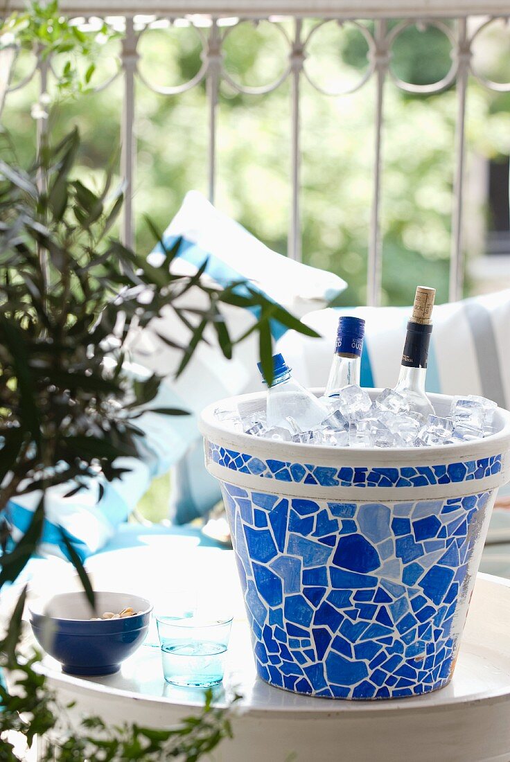 Mit Mosaikfliesenmuster bemalter Tontopf als selbstgestalteter Flaschenkühler