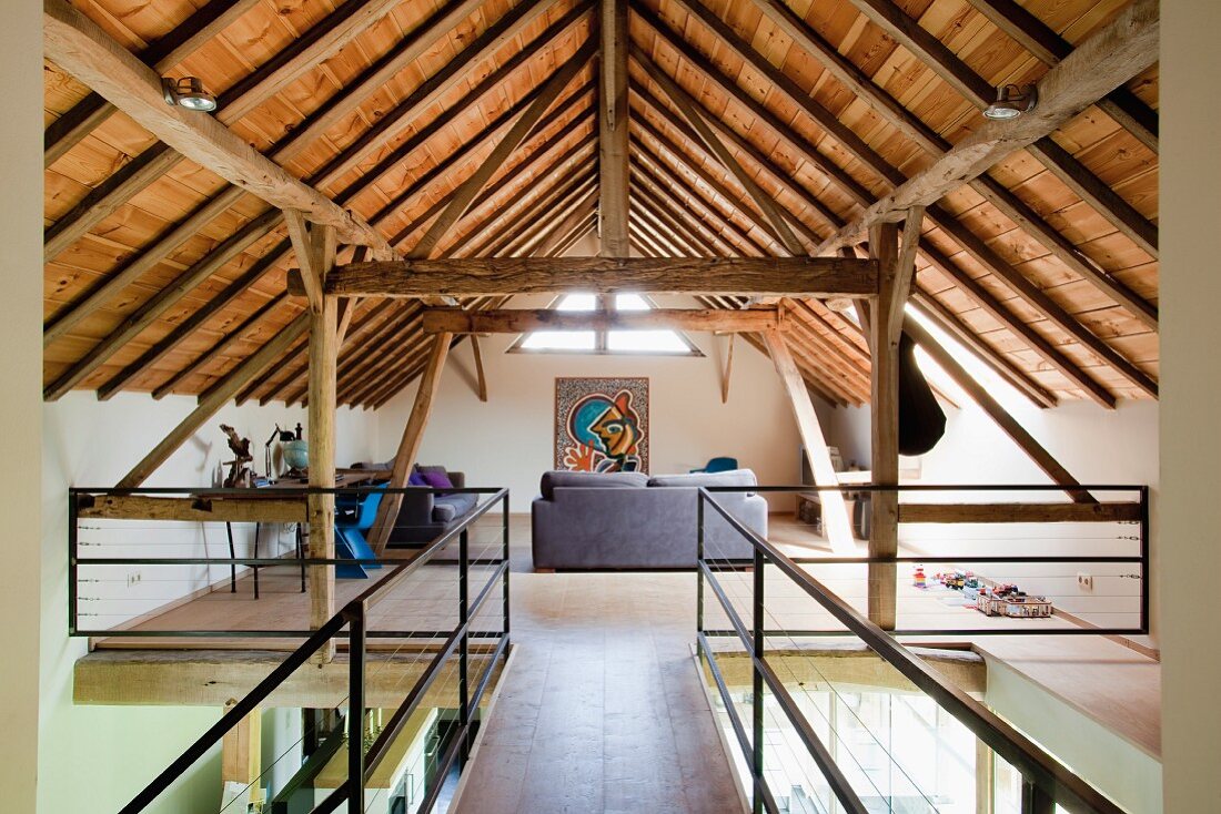 Renoviertes Dachgeschoss mit sichtbarer Holzkonstruktion und eingebauter Galerie mit moderner Loungeecke