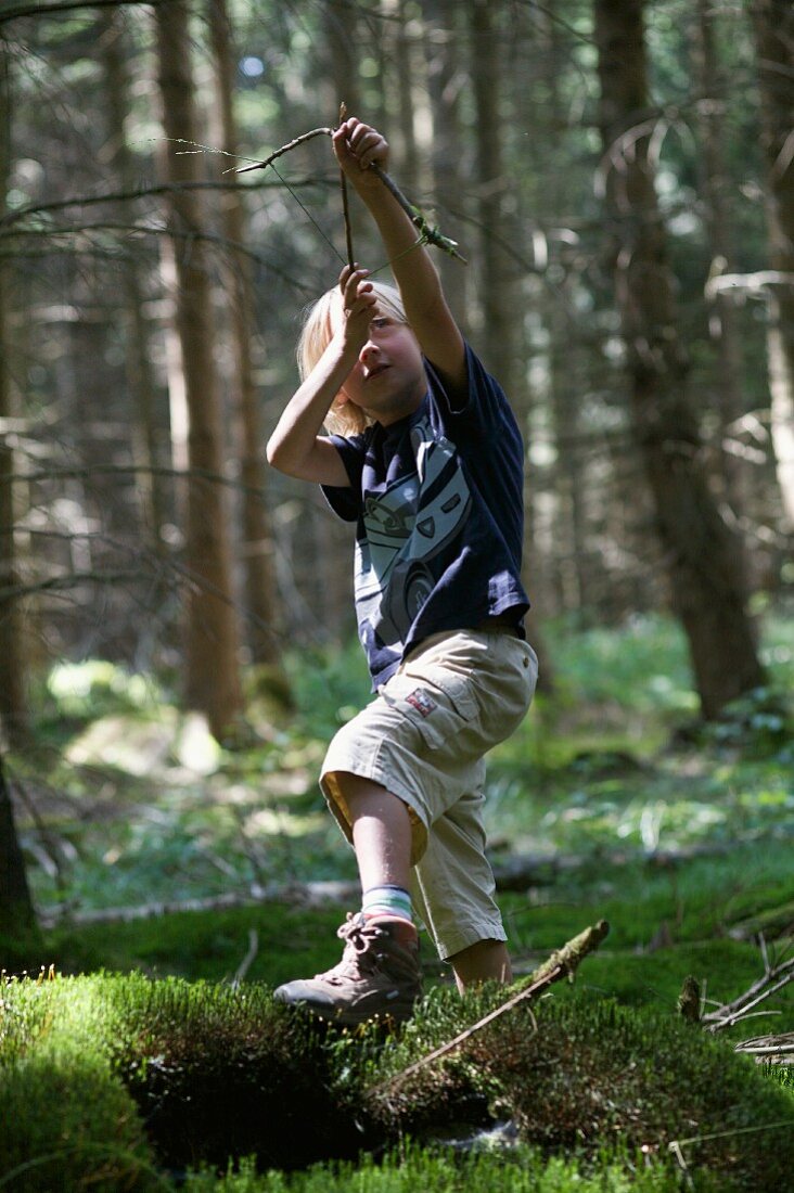Spielender Junge im Wald