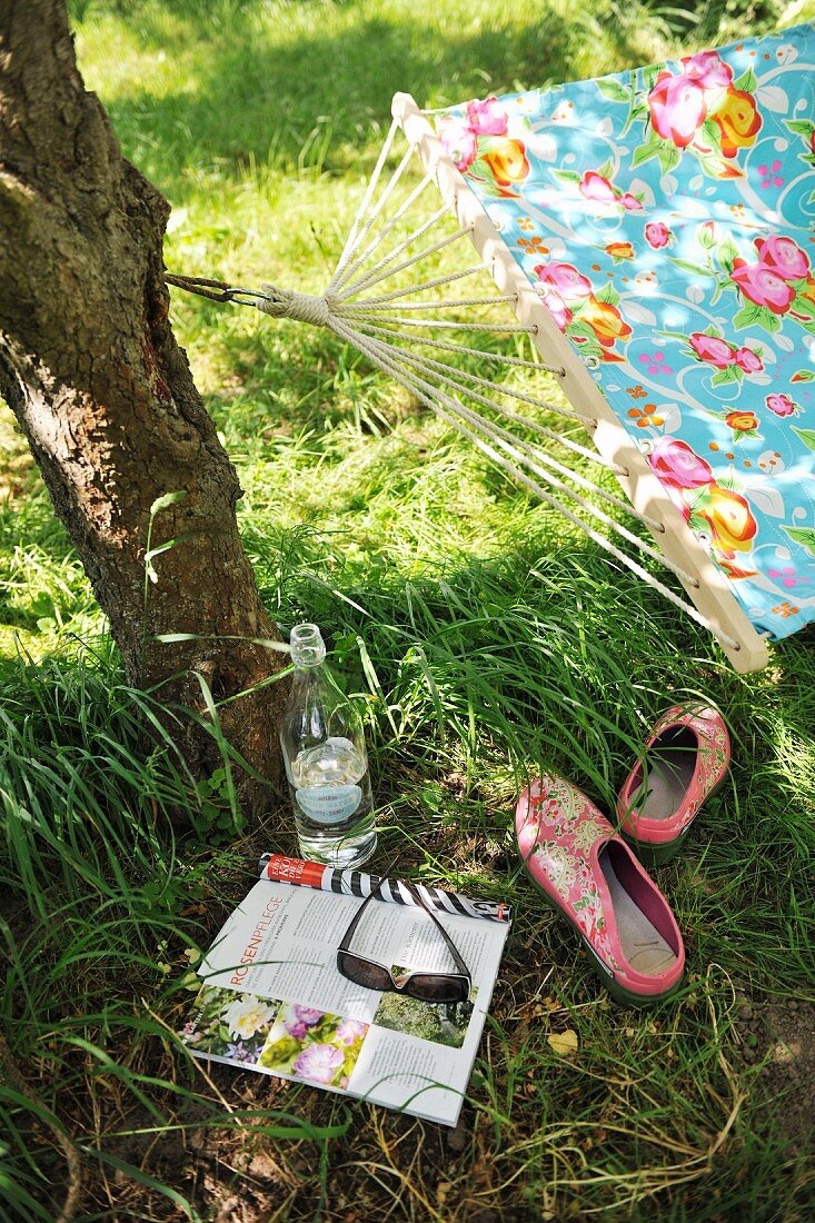 Ruhepause im Garten - Zeitung und Getränk unter schattenspendenden Baum