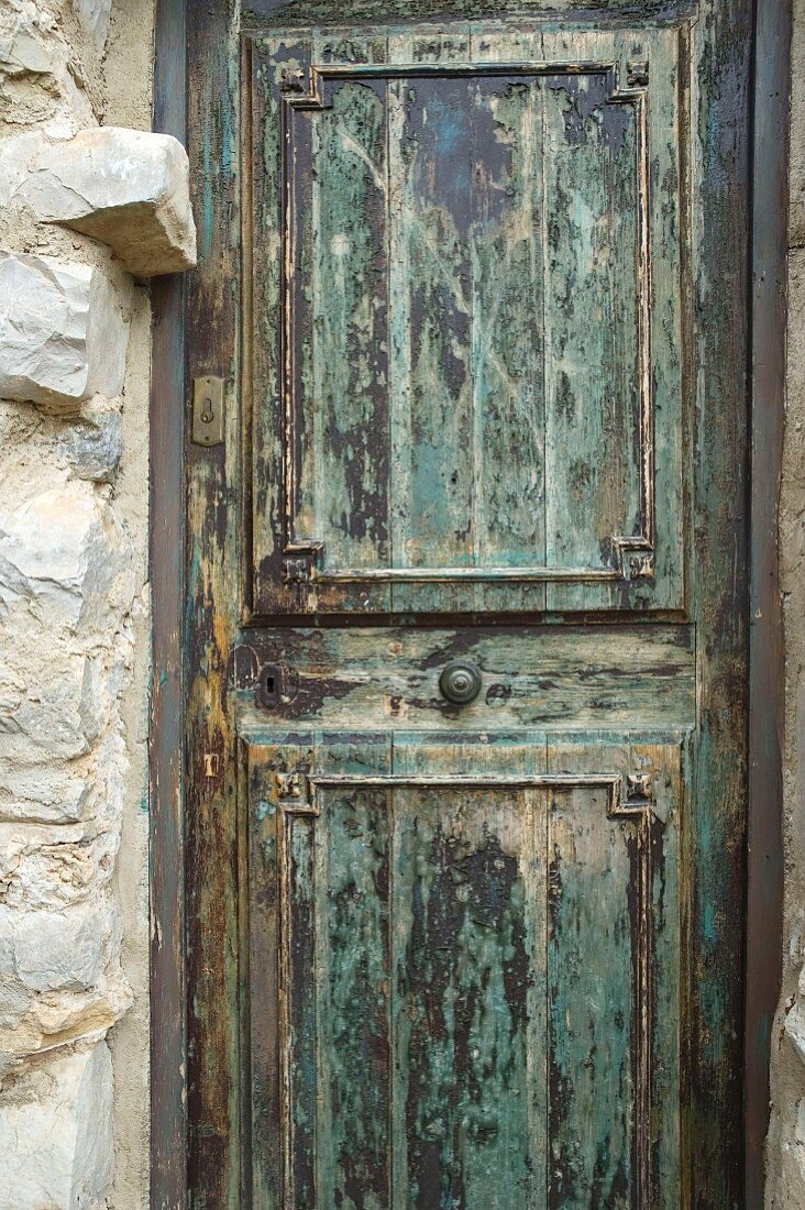 Weathered wooden door with patches of old paint