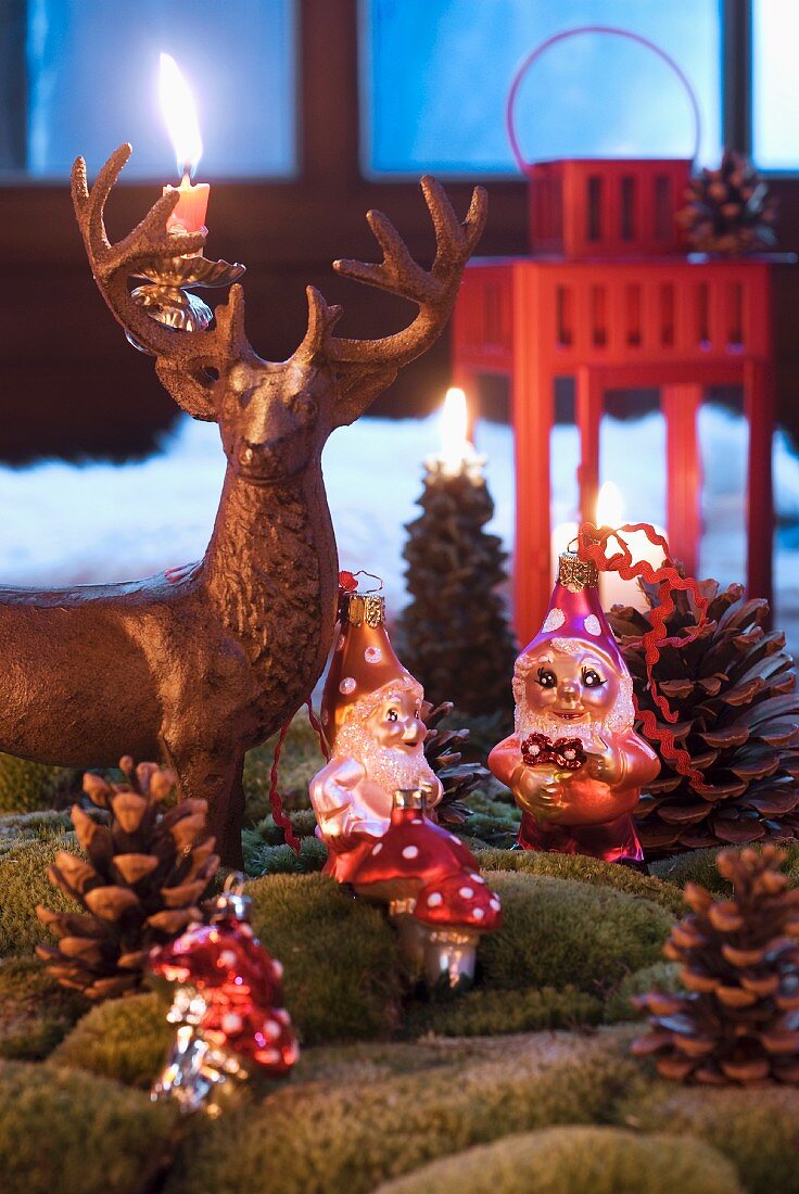 Hirschfigur aus Metall mit Kerzenhalter und Zwergenfiguren als Christbaumschmuck in künstlicher Landschaft