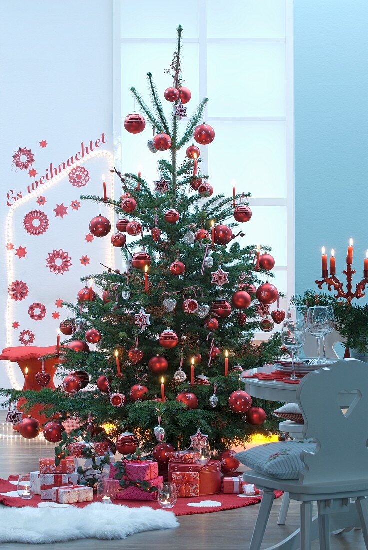 Heaps of presents under Christmas tree with red decorations