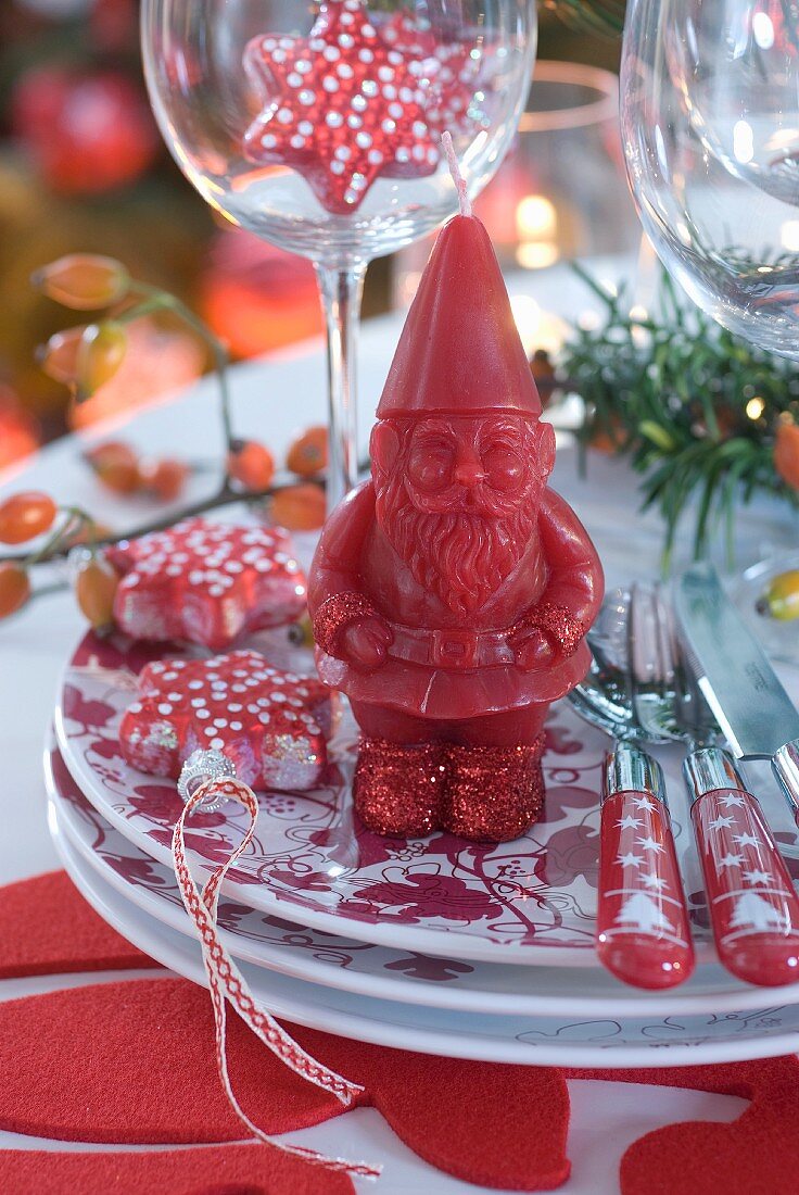 Red and white Christmas place setting with Father Christmas candle