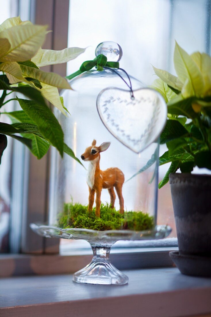 Deer figurine under bell jar as Christmas decorations