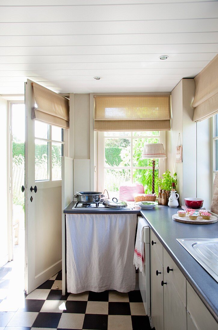 Country-style kitchen with base units and chequered floor