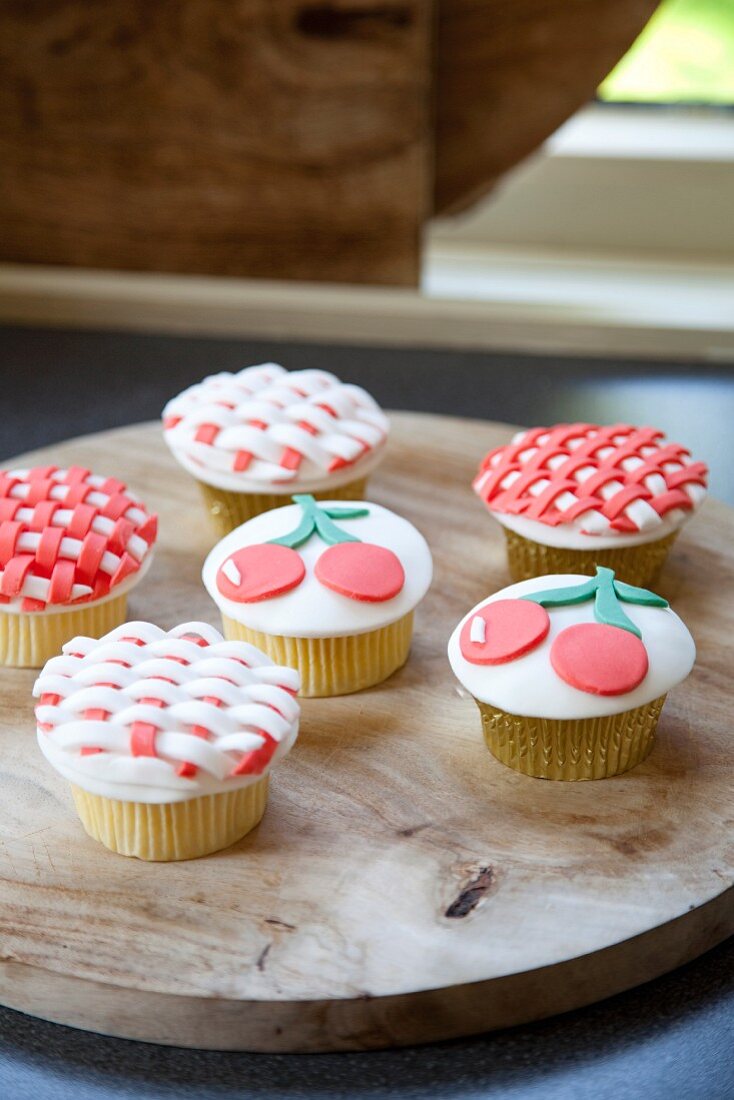 Decorated cupcakes on wooden board