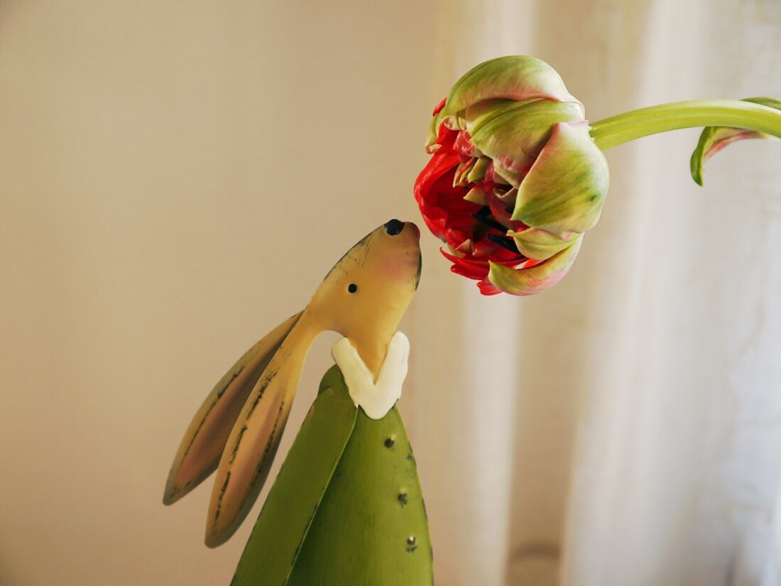 Hare figurine smelling flower