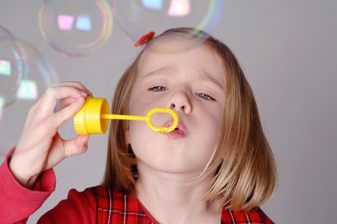 Blond girl blowing soap bubbles