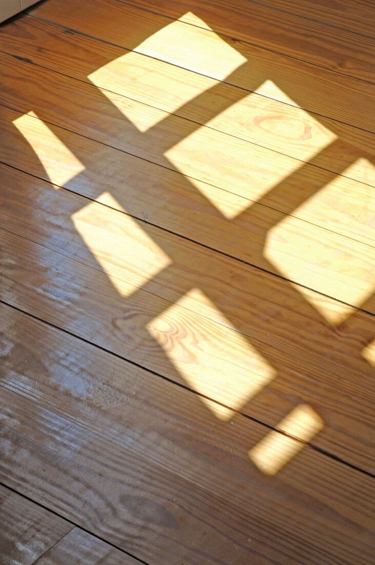 Sun shining through window on wooden floor