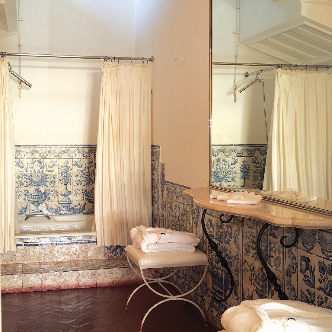 Vintage Badezimmer mit traditionellen, weiss blauen Fliesen an Wand und Duschvorhang an Badewanne