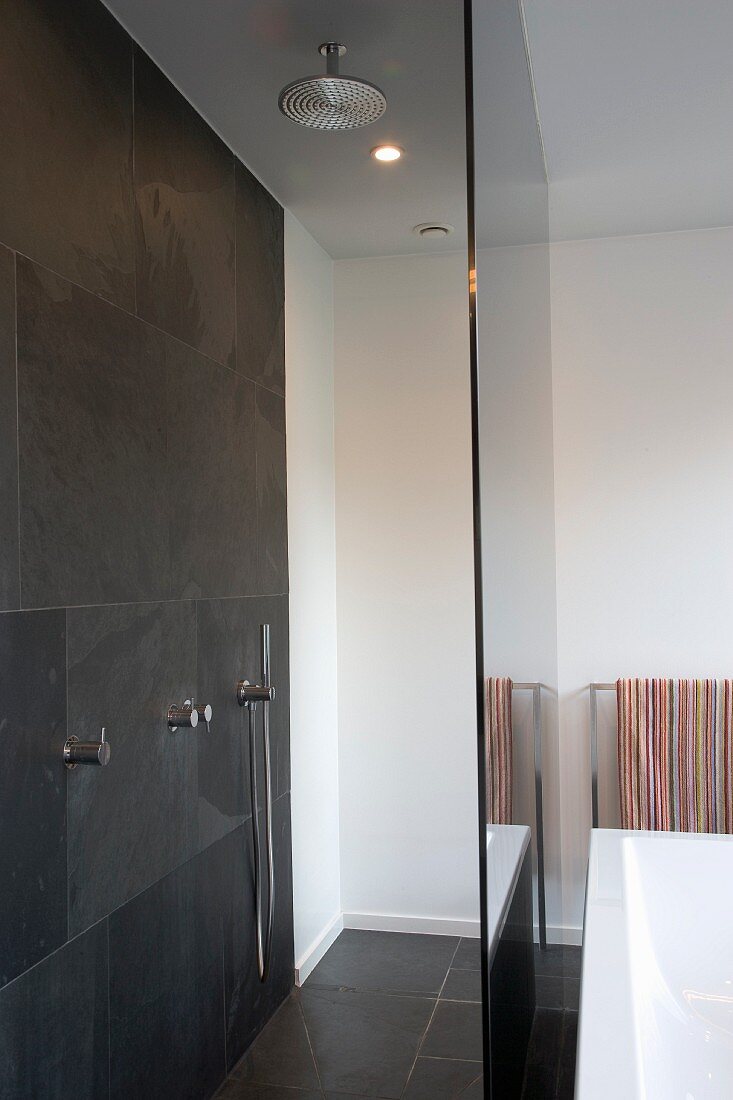 Dusche mit grauen Wandfliesen und Glastrennscheibe im Designer-Bad