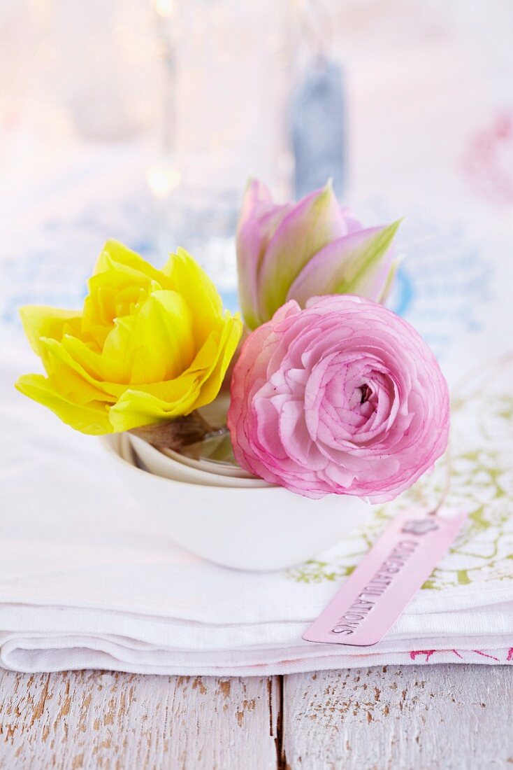 Double narcissus, pink ranunculus and tulip as table centrepiece