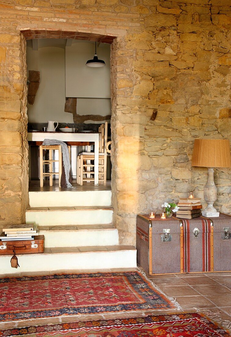 Teppichläufer im Vorraum mit Natursteinwand und Durchgang mit Stufen vor Esszimmer