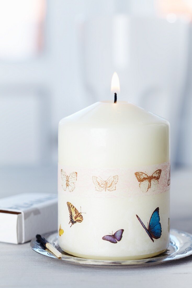 Masking Tape mit Schmetterlingsmotiven auf brennender Kerze