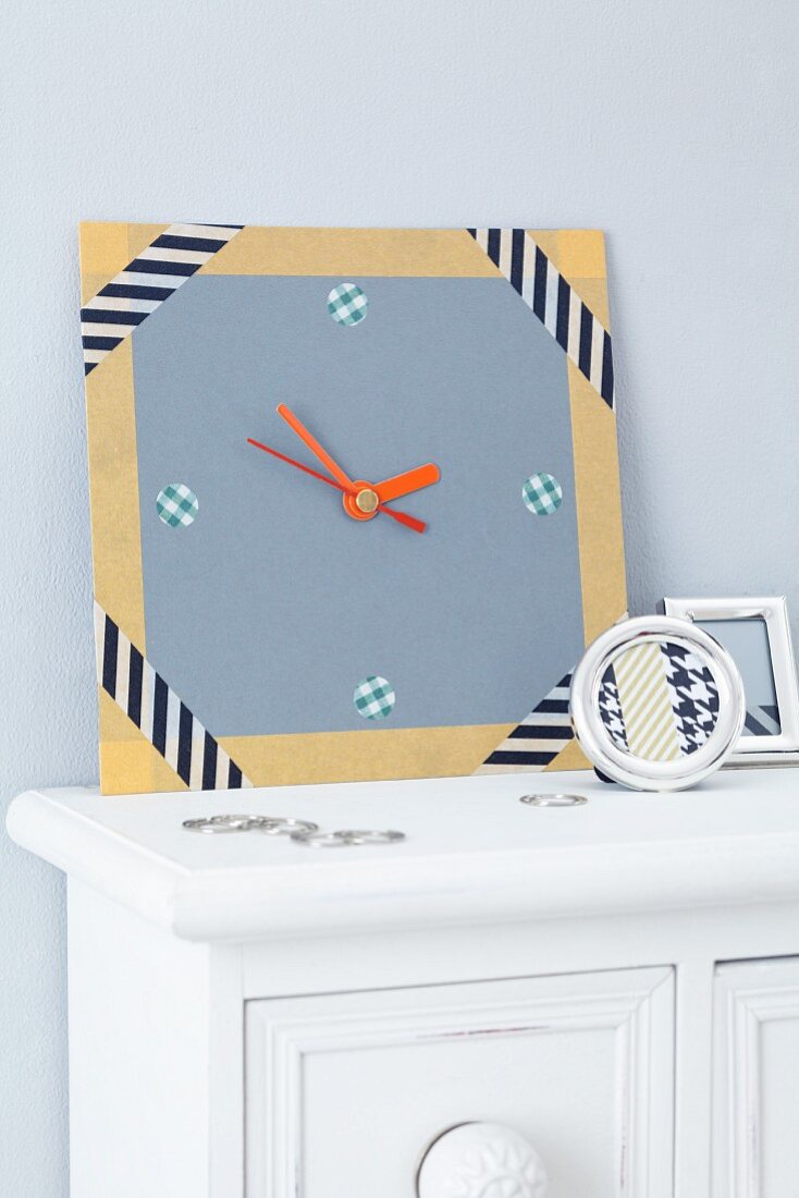 Home-made, cardboard wall clock decorated with patterned tape