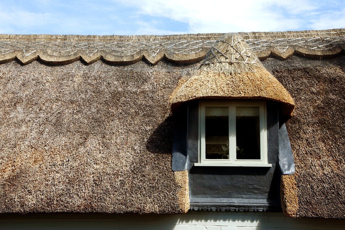Traditional, English-style thatched roof with dormer window