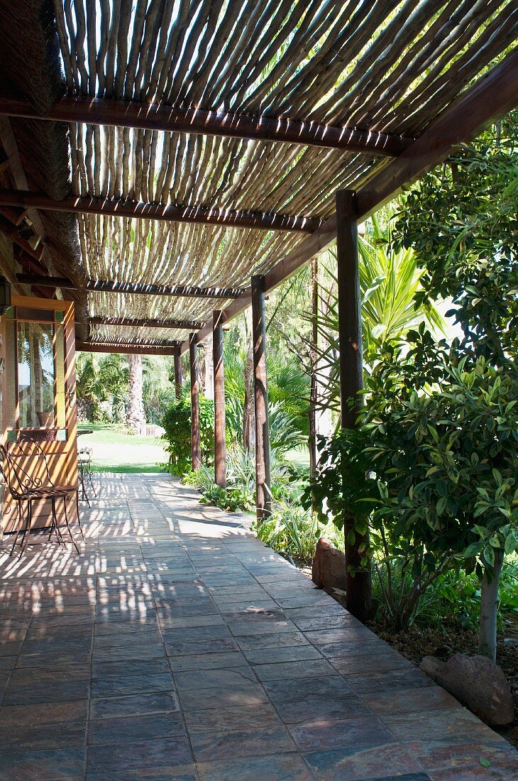 Terrasse mit Pergola und Blick in tropischen Garten