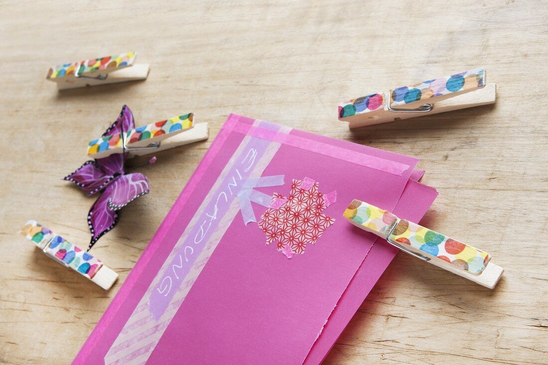 A hand-decorated envelope and decorated wooden clothes pegs