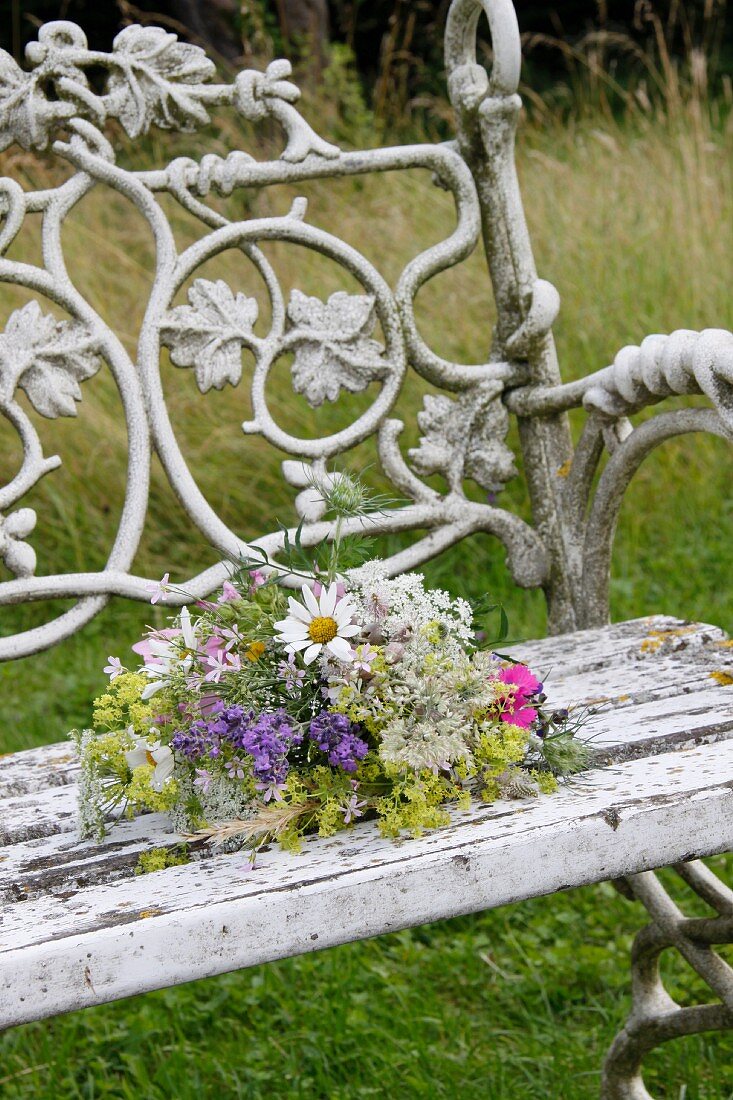 Posy of wild flowers on garden bench