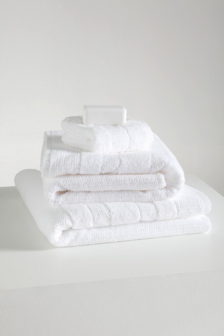 Stack of white towels on a white shelf