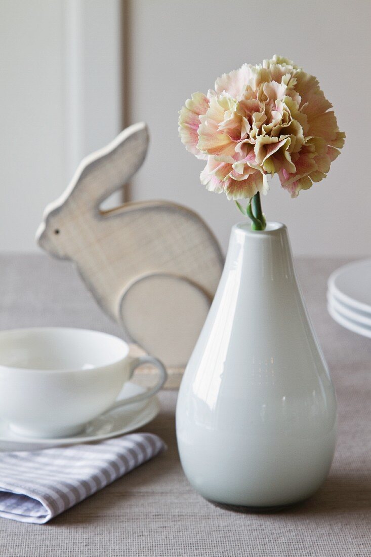 Osterstimmung - Porzellanvase mit Nelke auf Frühstückstisch