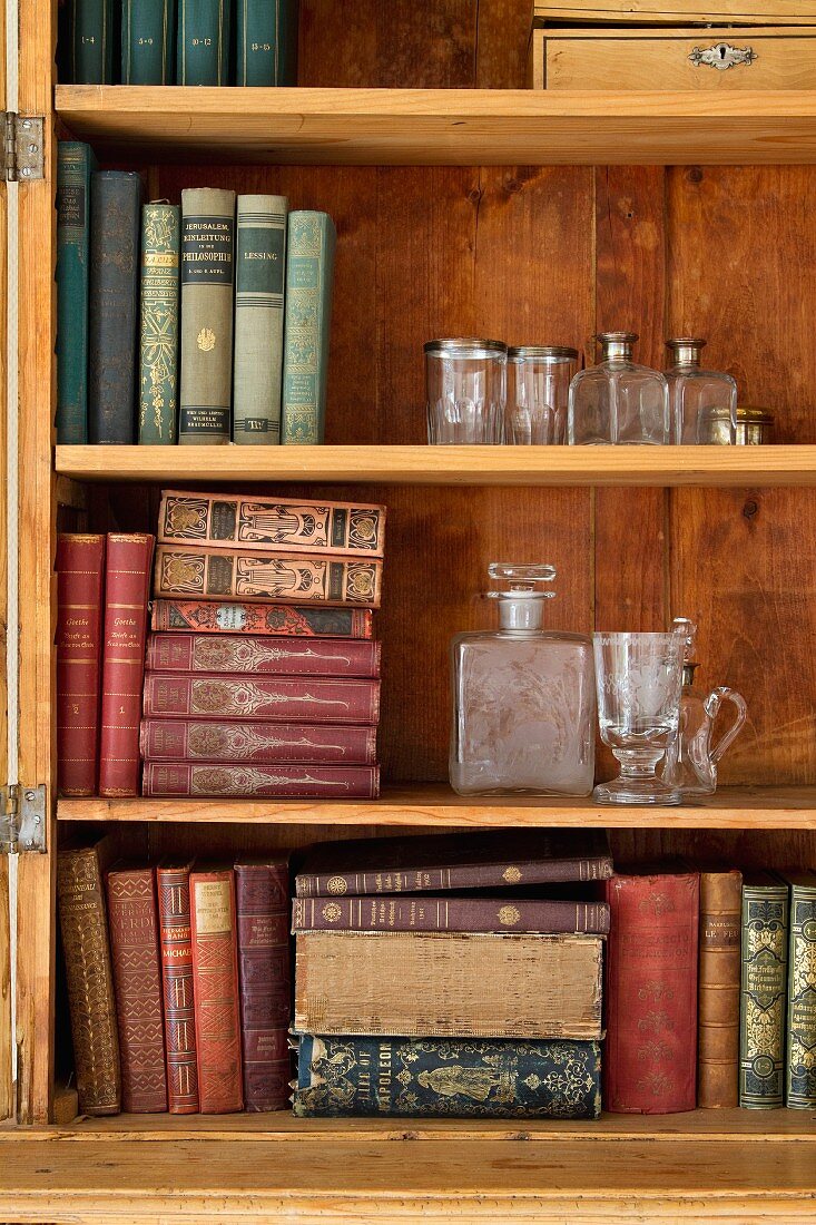 Offener Schrank aus Holz mit antiquarischen Büchern und Glasbehältern