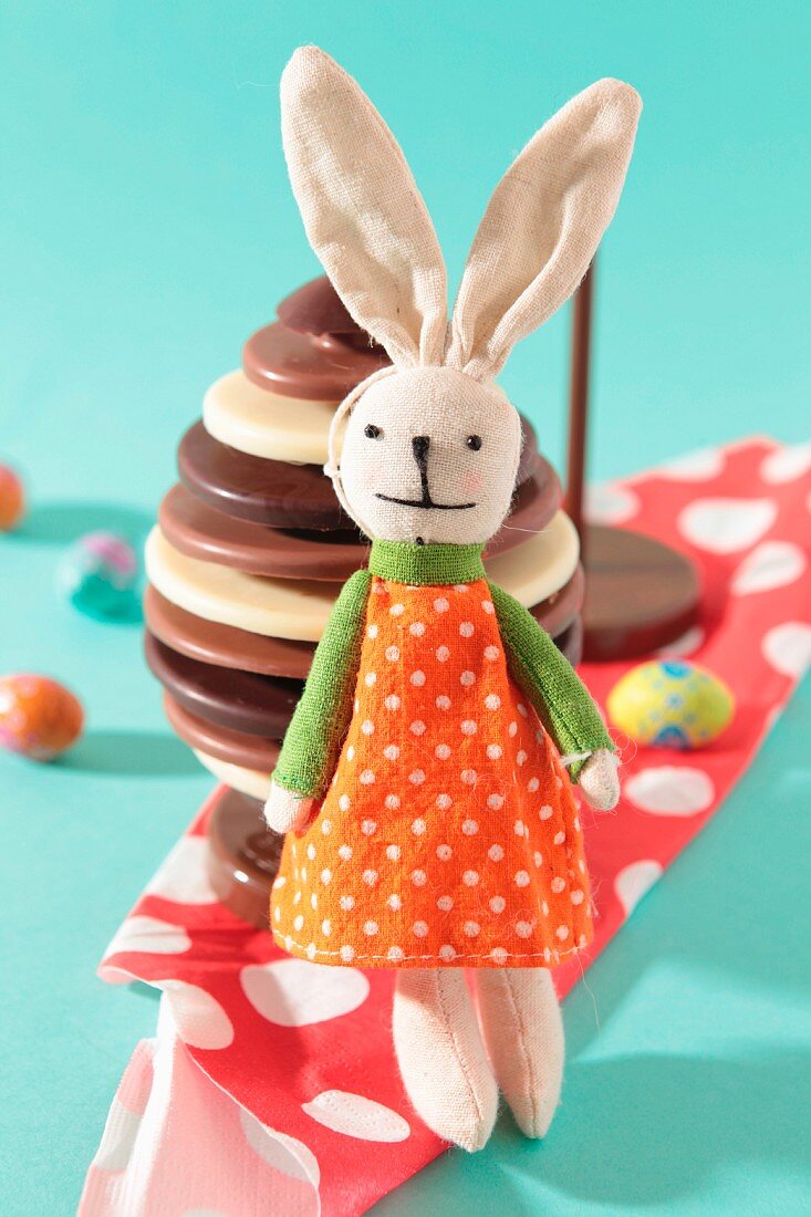 Plush rabbit toy in front of a chocolate Easter egg
