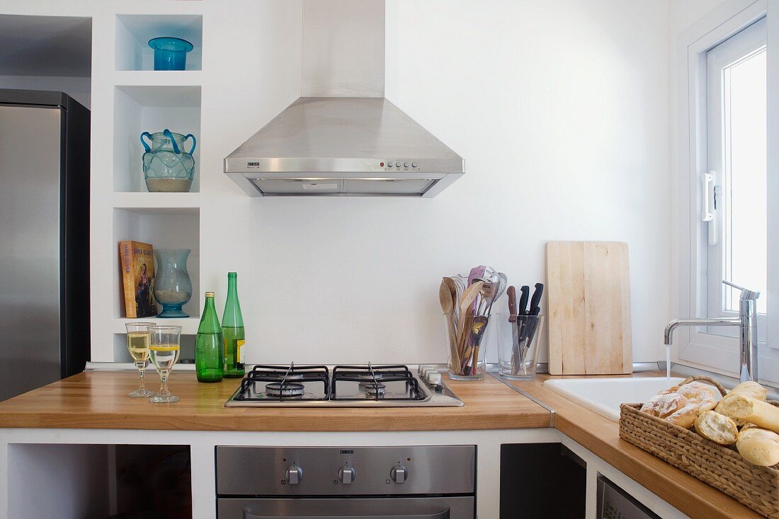 Moderne Küchenzeile mit Holzarbeitsplatte und Dunstabzug aus Edelstahl