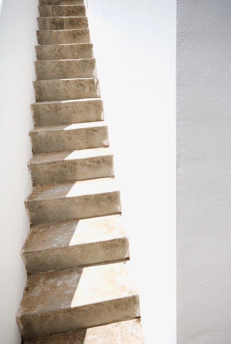 Schmaler Treppenaufgang aus Naturstein zwischen den Hausmauern