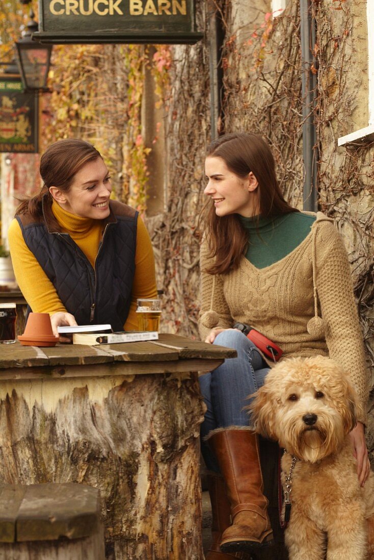 Zwei Frauen mit Hund in rustikalem Café