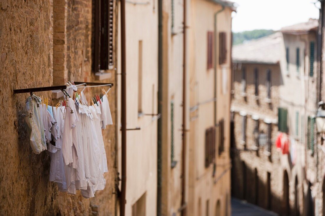 Wäsche hängt zum Trocken vor einem Fenster (Italien)