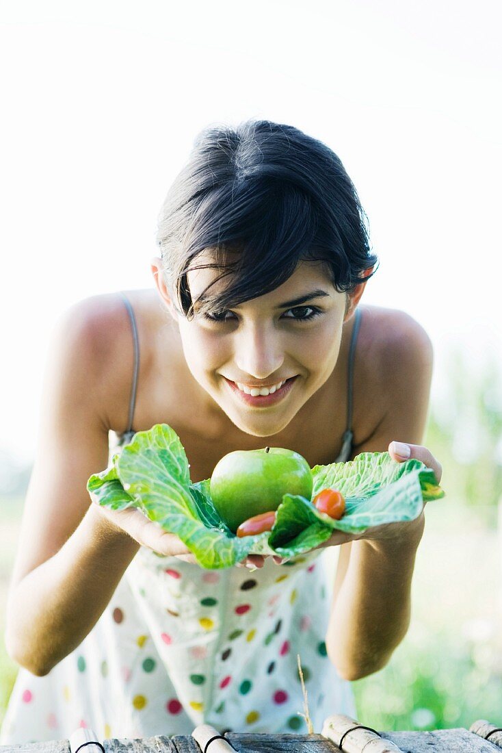 Frau hält kleine Ernte auf Kohlblatt in den Händen