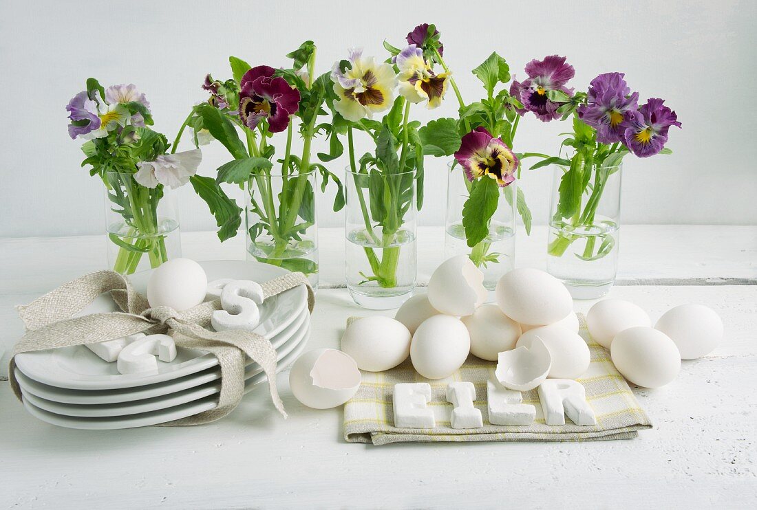 Österliche Tischdeko mit Stiefmütterchen & ausgeblasenen Eiern