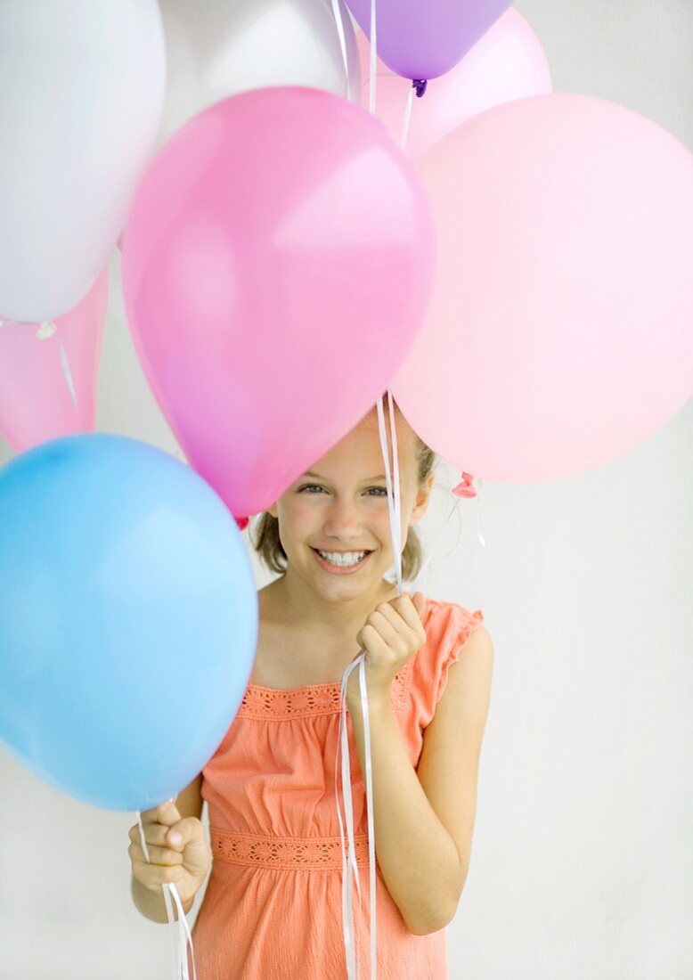 Lachendes Kind mit Luftballons in der Hand