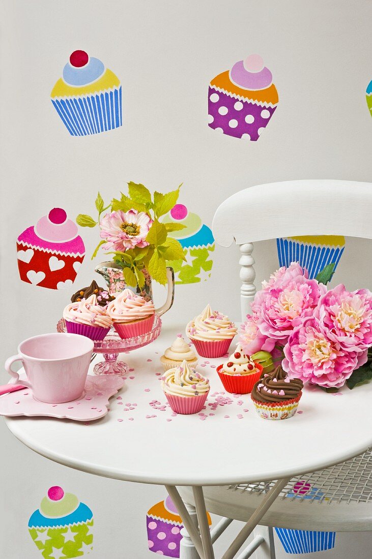 Cakes in colourful cases on side table against wall with cake-themed wall stickers