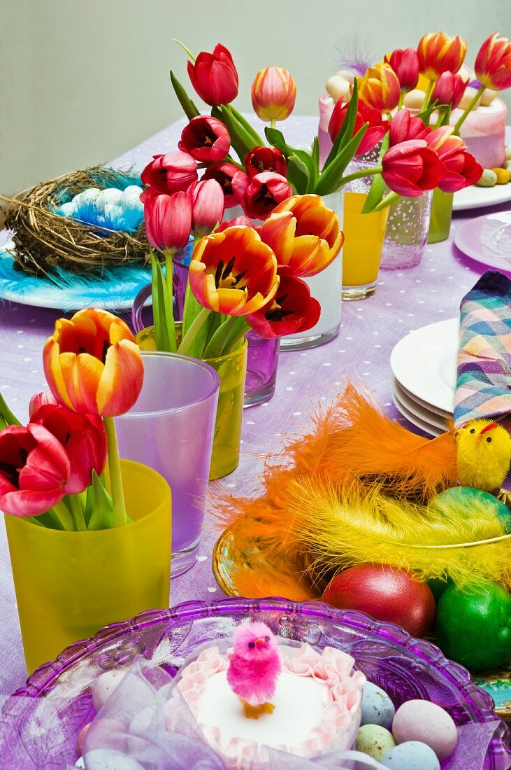 Bunte, geschmückte Tafel mit Blumensträußen und farbiger Osterdeko