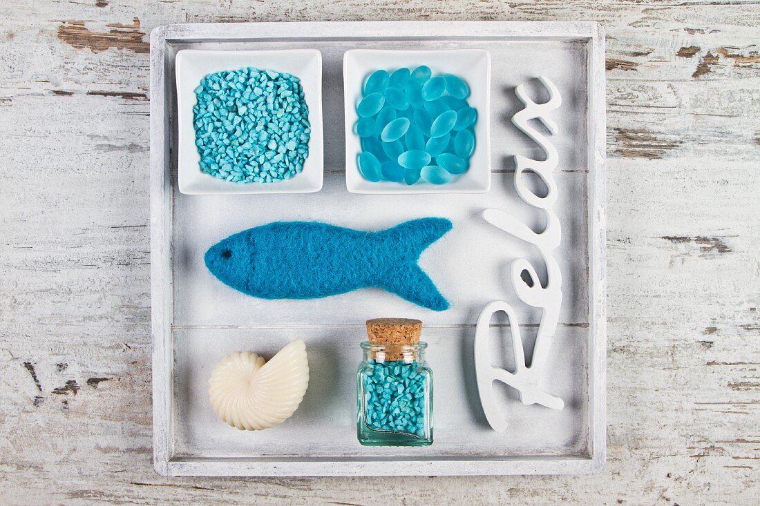 Maritime decoration with turquoise bath salts and bath pearls and a fish-shaped sponge