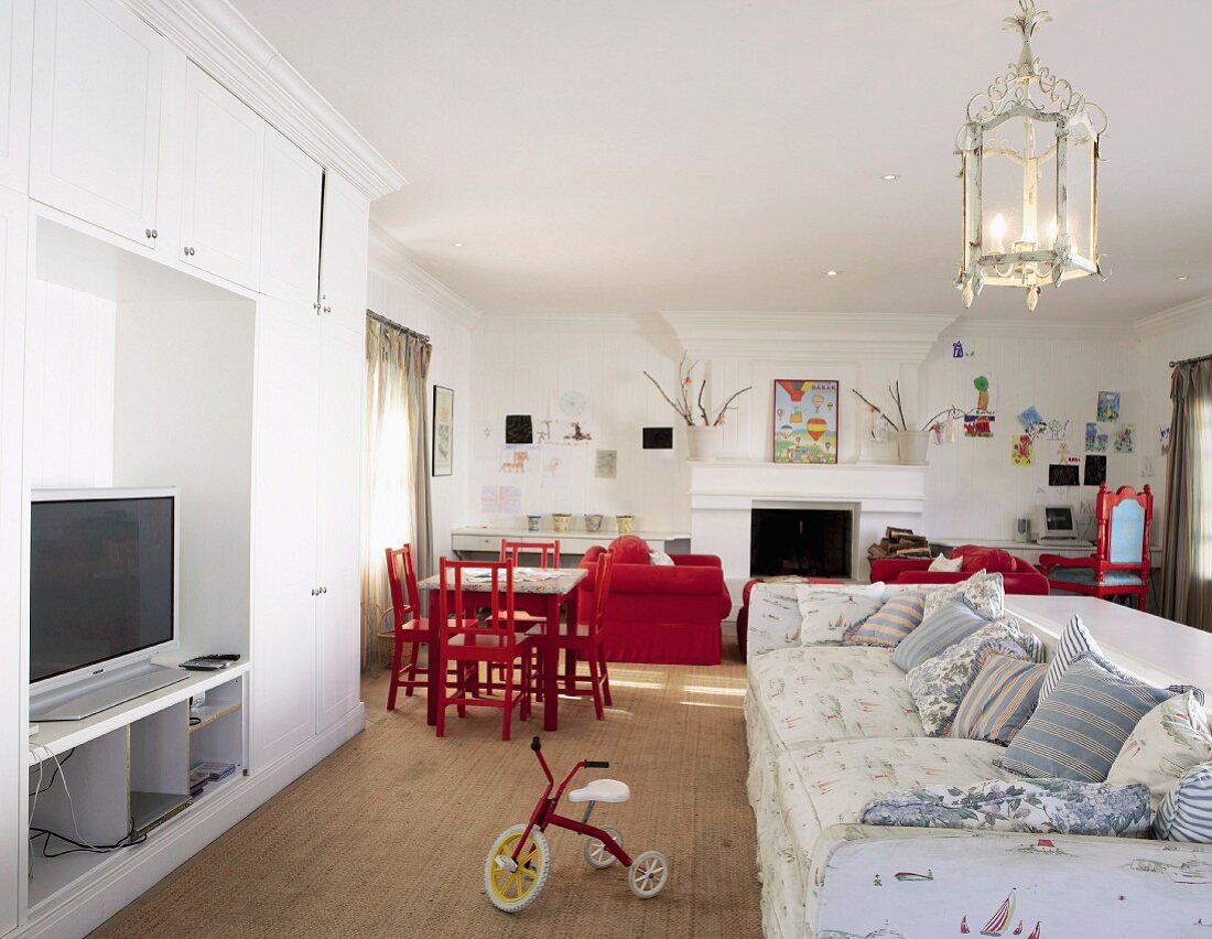 Offener Wohnraum mit Sofagarnitur, Fernsehregal und Spielbereich für Kinder