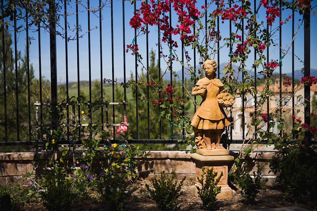 Mädchenfigur aus Stein in mediterranem Garten