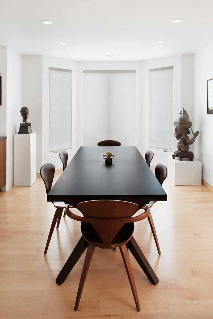 A large airy dining room with two sculptures on pedestals in the background