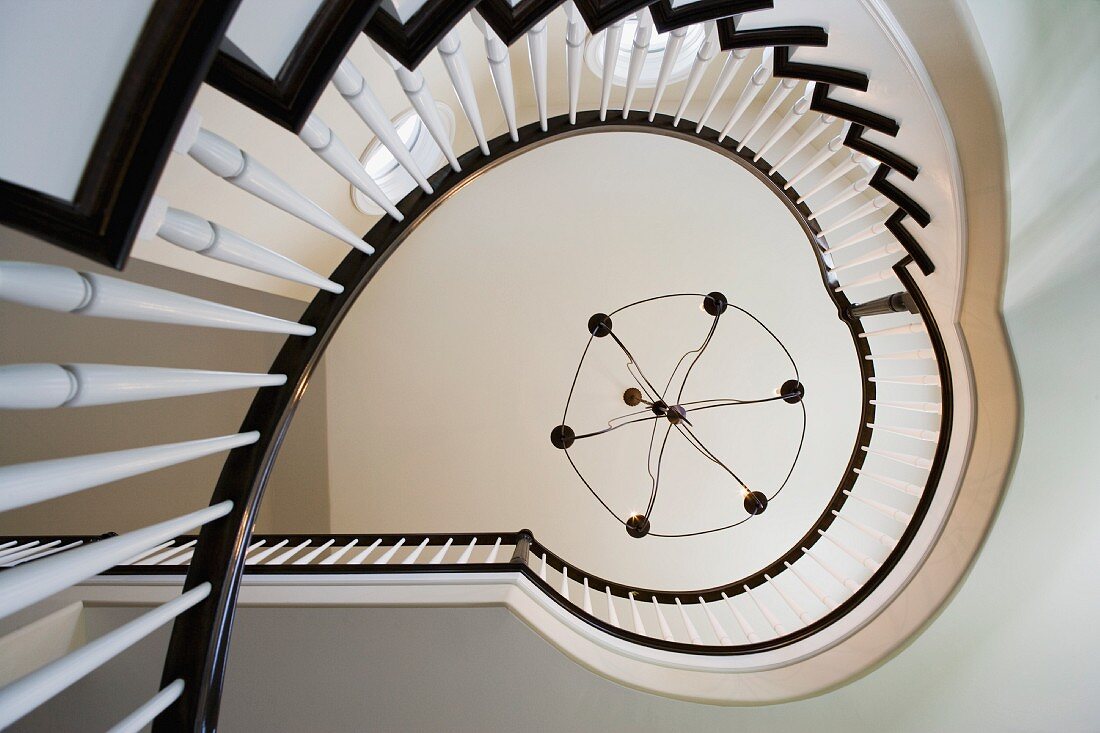 Looking up at contemporary winding staircase and contemporary chandelier