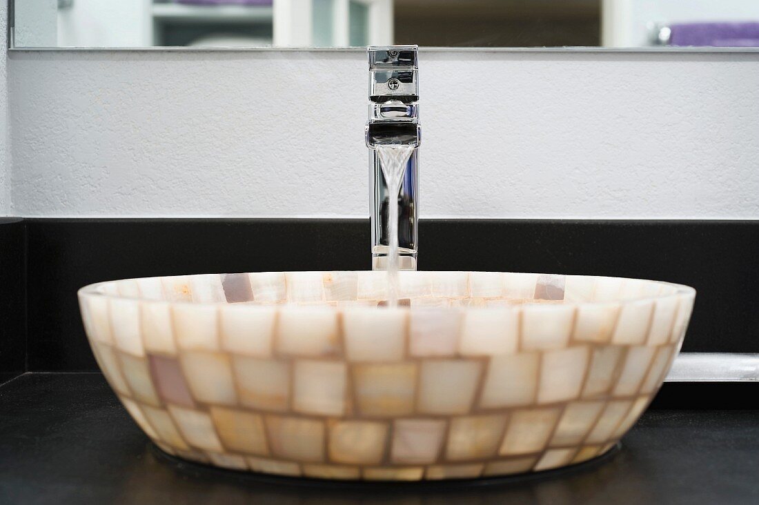 Waschschüssel aus hellen Glasmosaiksteinen und Designer Armatur