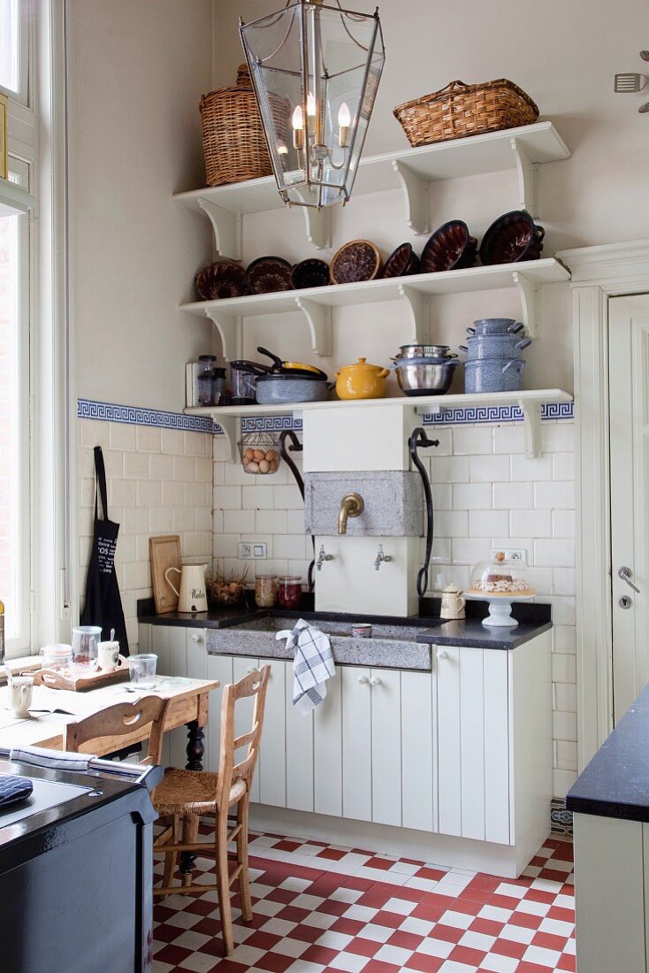 Simple kitchen counter in rustic kitchen dining room with red and white chequered floor