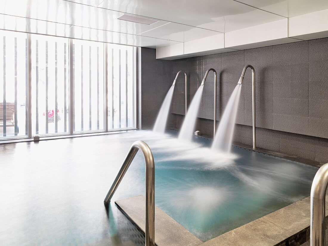 Schwallduschen in Betrieb an Indoor Pool in zeitgenössischer Architektur