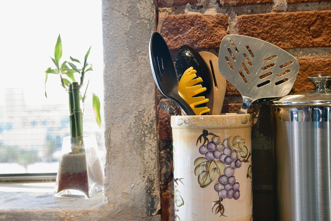 Detail of kitchen utensils next to window.