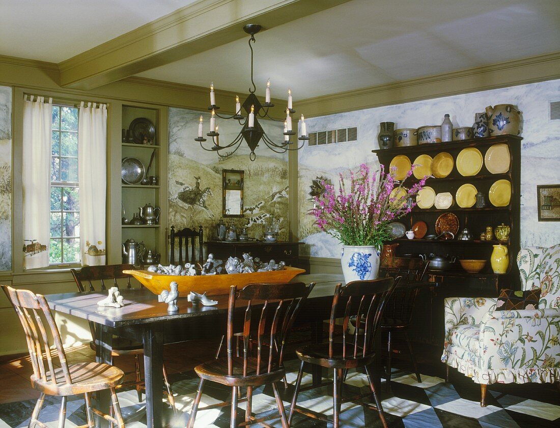 Dark furniture characterise a dining room with a collection of crockery, stoneware, pewter and knickknacks
