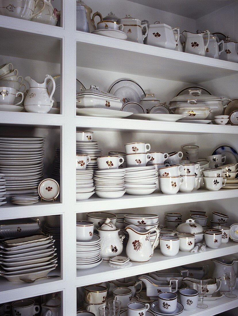 White shelving with large collection of fine china