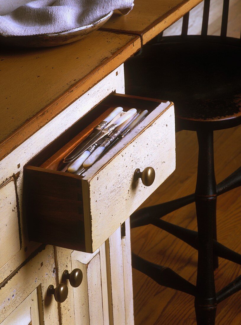 Open drawer in vintage kitchen cupboard
